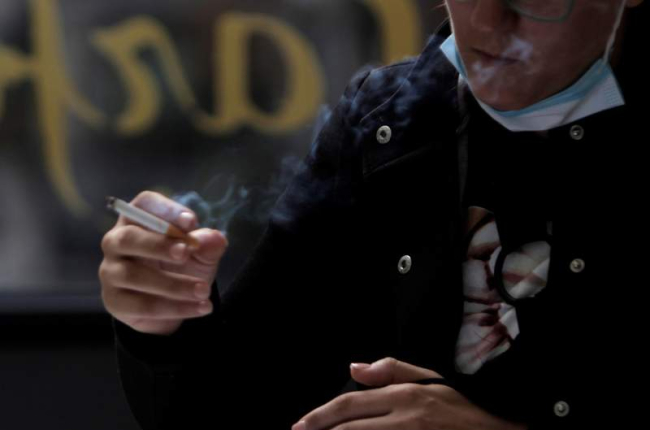 Una mujer fumando en la terraza de un bar en el centro de la ciudad de A Coruña. CABALAR