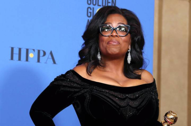Oprah sostiene un premio en los Globos de Oro