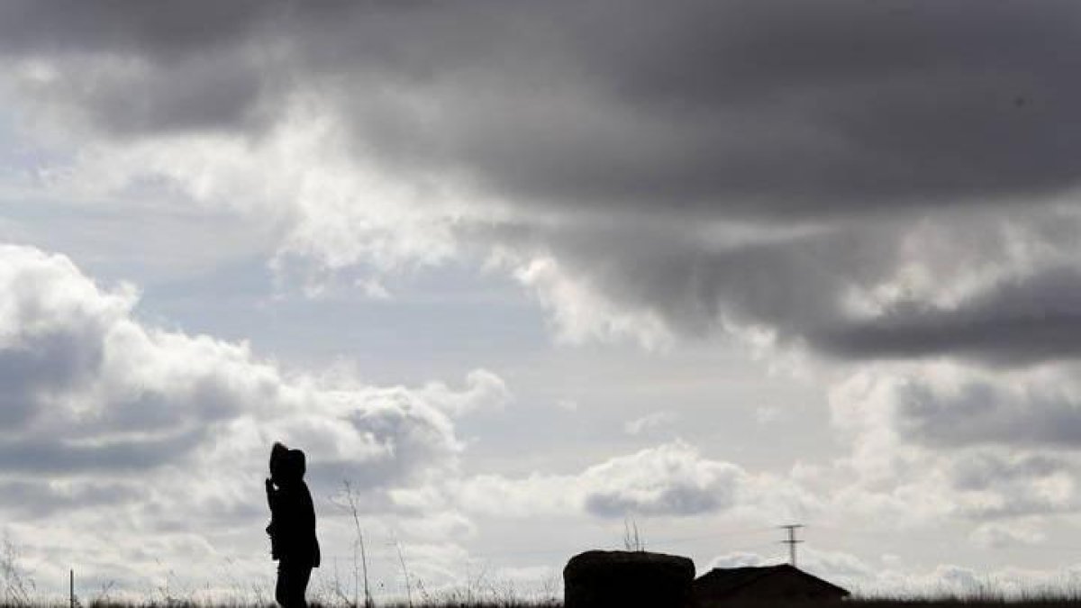 Un hombre observa el cielo nublado