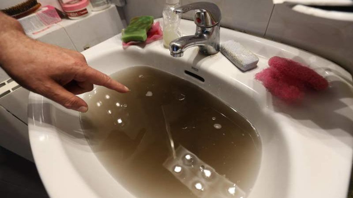 Imagen de archivo de agua de la traída sucia y embarrada en un pueblo de León, igual que la que está saliendo en cientos de viviendas en León capital.