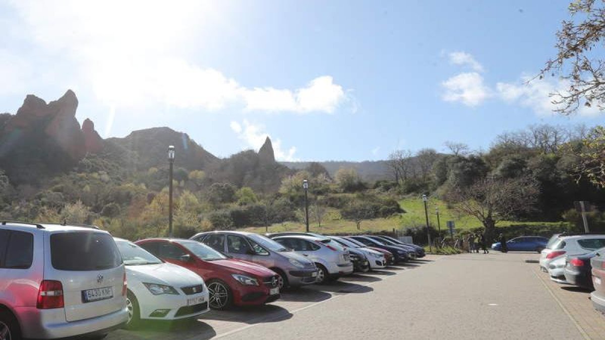 Coches estacionados en un aparcamiento habilitado para acceder a la visita de las Médulas.