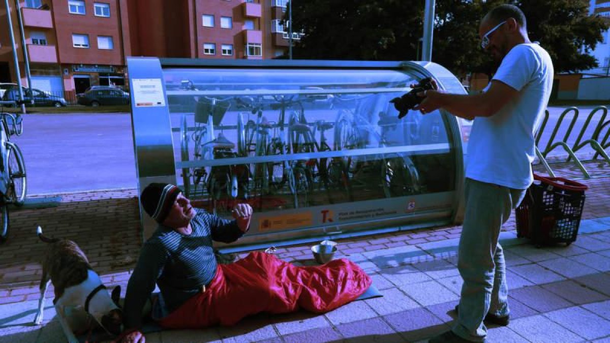 Salvador Armesto, con su perra Paca, durante la acción artístico-reivindicativa al lado de una cabina de bicis.  RAMIRO