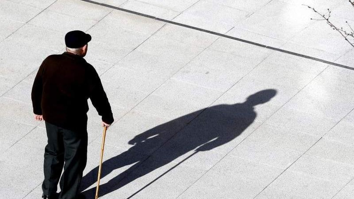 Un anciano pasea por la calle.