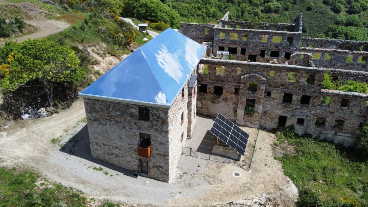 El tejado de aluminio-espejo atrapa las nubes en el antiguo economato del poblado de La Piela, reconvertido en el centro de visitantes La Montaña Negra