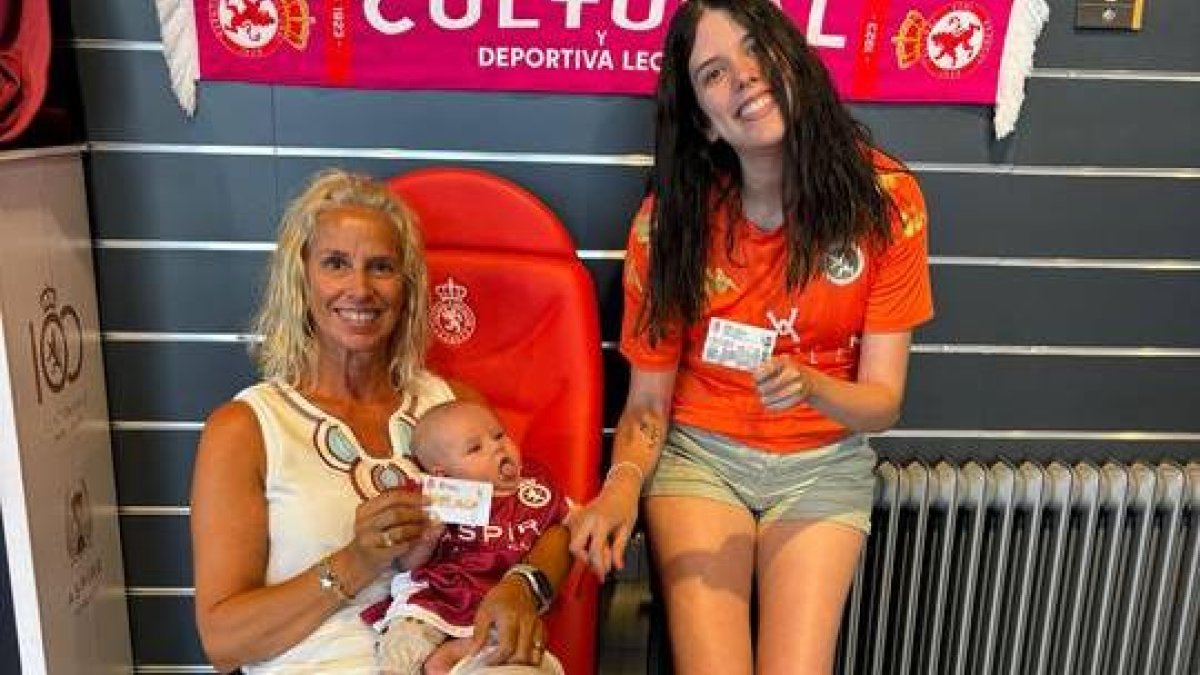 Alba, en brazos de su orgullosa abuela Ana y al lado de su madre Rocío con su carnet de socia de la Cultural.