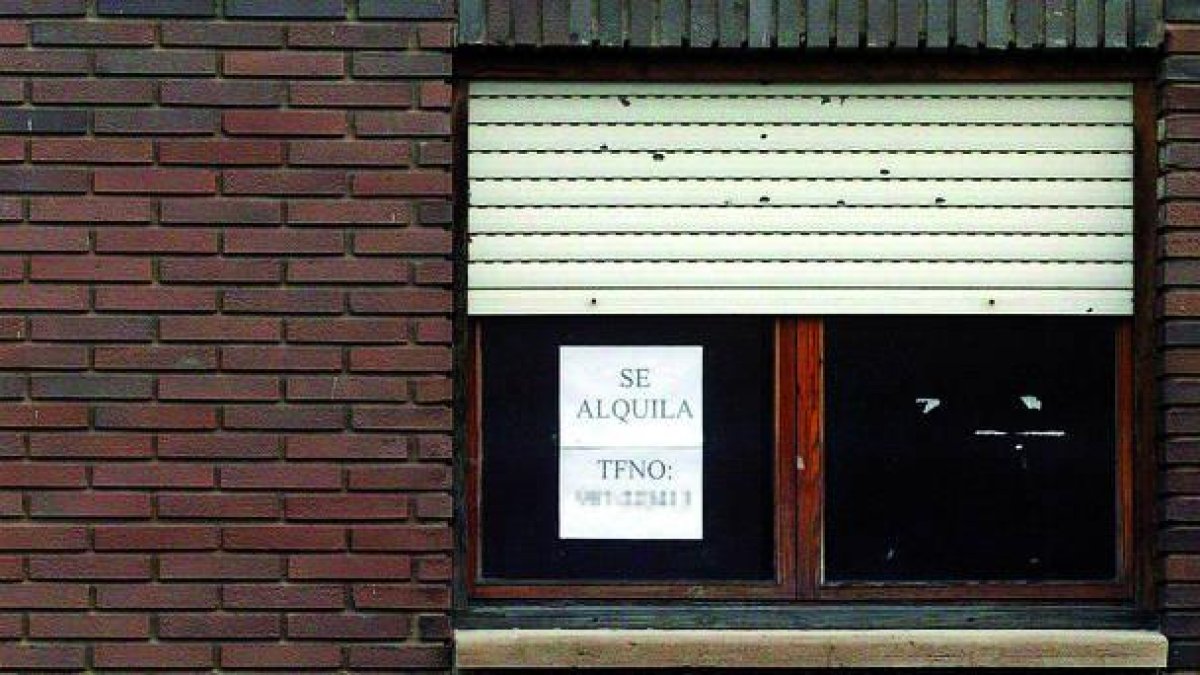 Cartel de Se alquila en la ventana de una vivienda de León.