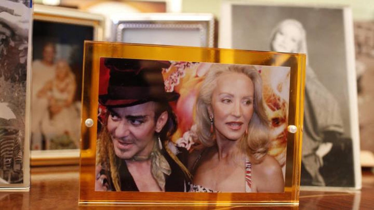 Una de las fotos preferidas de Carmen Lomana. Está con el diseñador John Galliano, en uno de los muebles de su residencia madrileña. La imagen enmarcada fue realizada durante una entrevista en 2010.