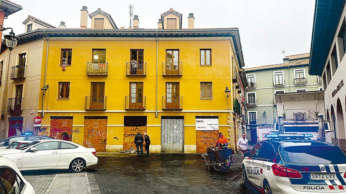 Policías locales junto al edificio que merodean los okupas.