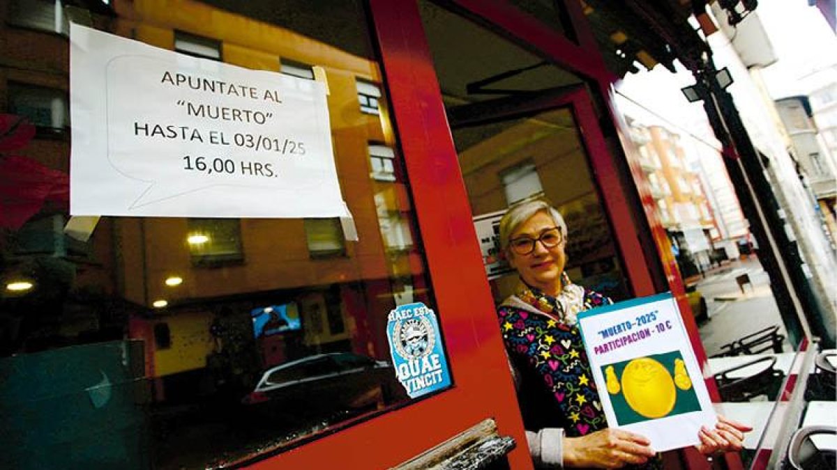 La responsable del bar Gómez de Ponferrada, ayer con el cartel «Apúntate al ‘Muerto’».