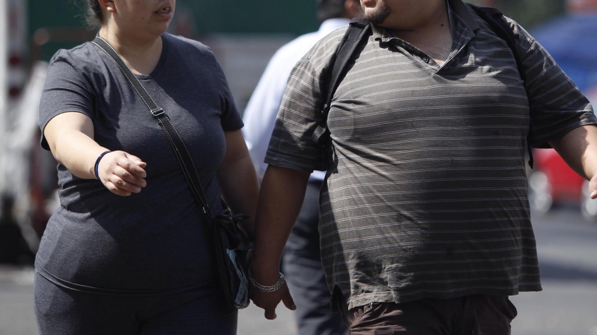 Personas con obesidad caminan por la calle.