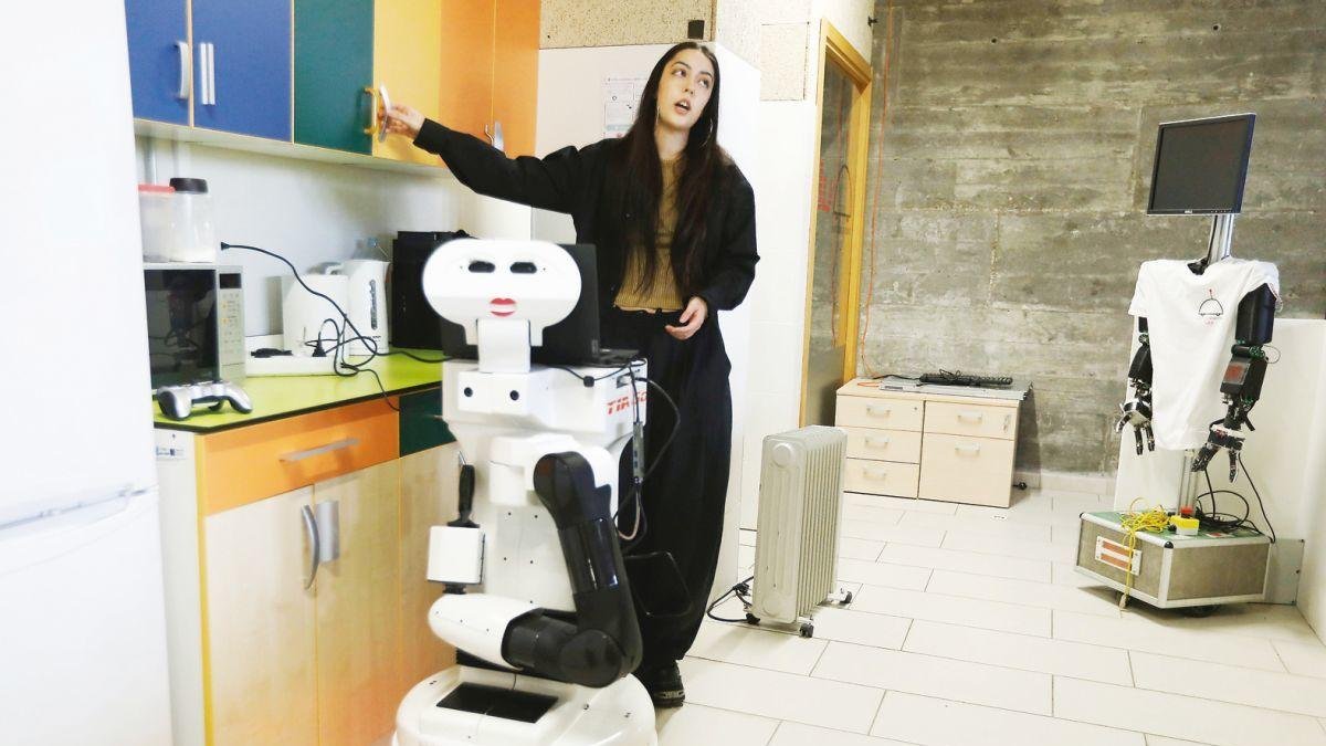 Demostración de un robot cuadrúpedo en el MIC ante alumnado de Bachillerato. Karen y otro robot en la demostración sobre usos en casa.