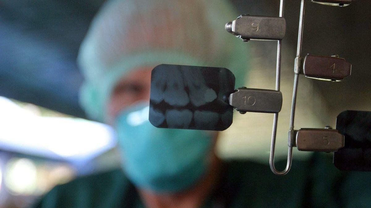 Un dentista muestra una radiografía de unos dientes.