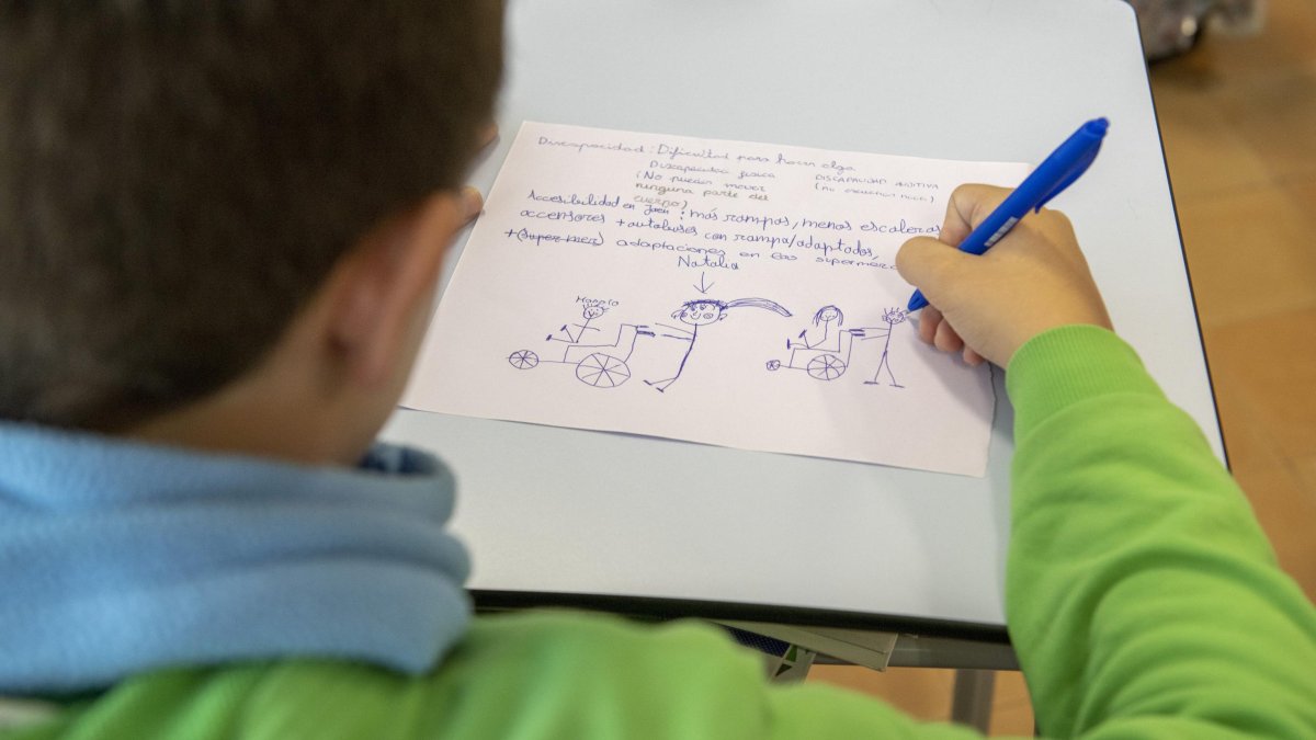 Un niño dibujando en el aula de su colegio.