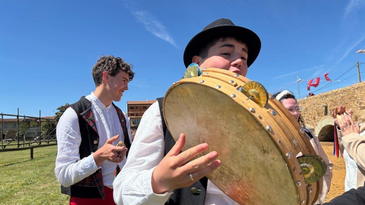 Por un lado los bailadores sobre la ribera del Órbigo realizando una danza tradicional, por el otro un joven ribereño con su pandereta.