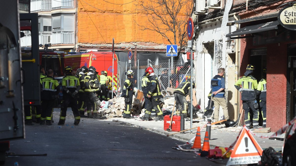 Equipos de emergencias trabajan en la zona donde se ha producido la explosión, que ha tenido lugar en el bar-restaurante Mis tesoros, ubicado en la calle Manuel Maroto de Puente de Vallecas.