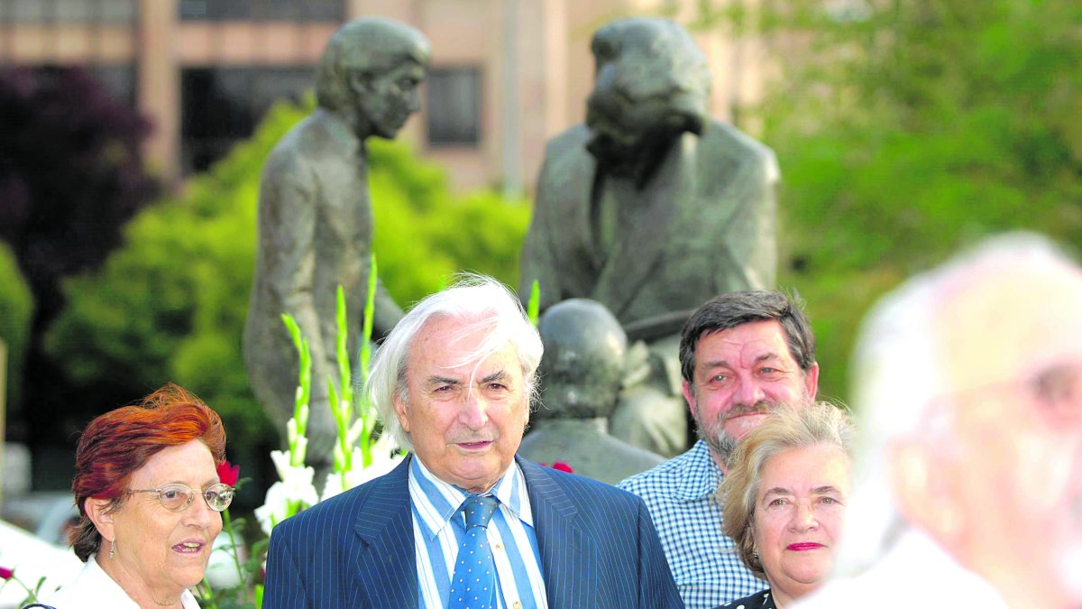 Odón Alonso en primer término y detrás la escultura que el Ayuntamiento dedicó a su padre en la Condesa