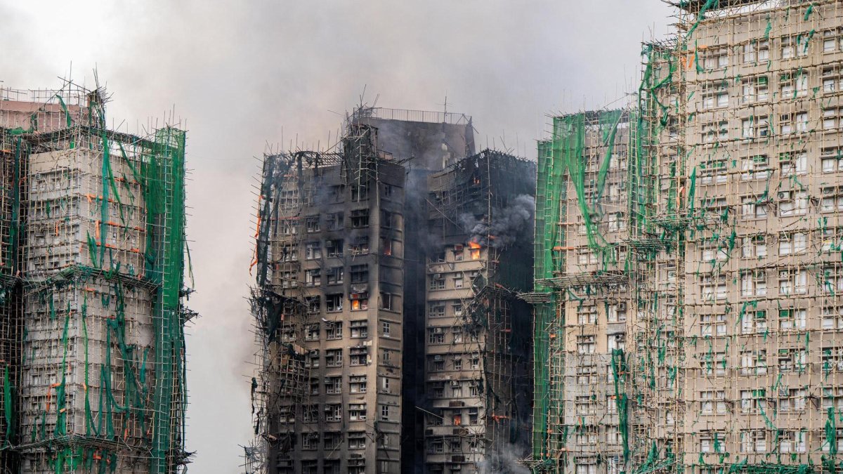 Una nube de humo sale desde uno de los edificios calcinados en Hong Kong, con decenas de víctimas mortales.
                      EFE/EPA/LEUNG MAN HEI.