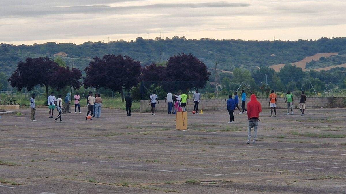 Migrantes juegan al fútbol en las afueras de León.