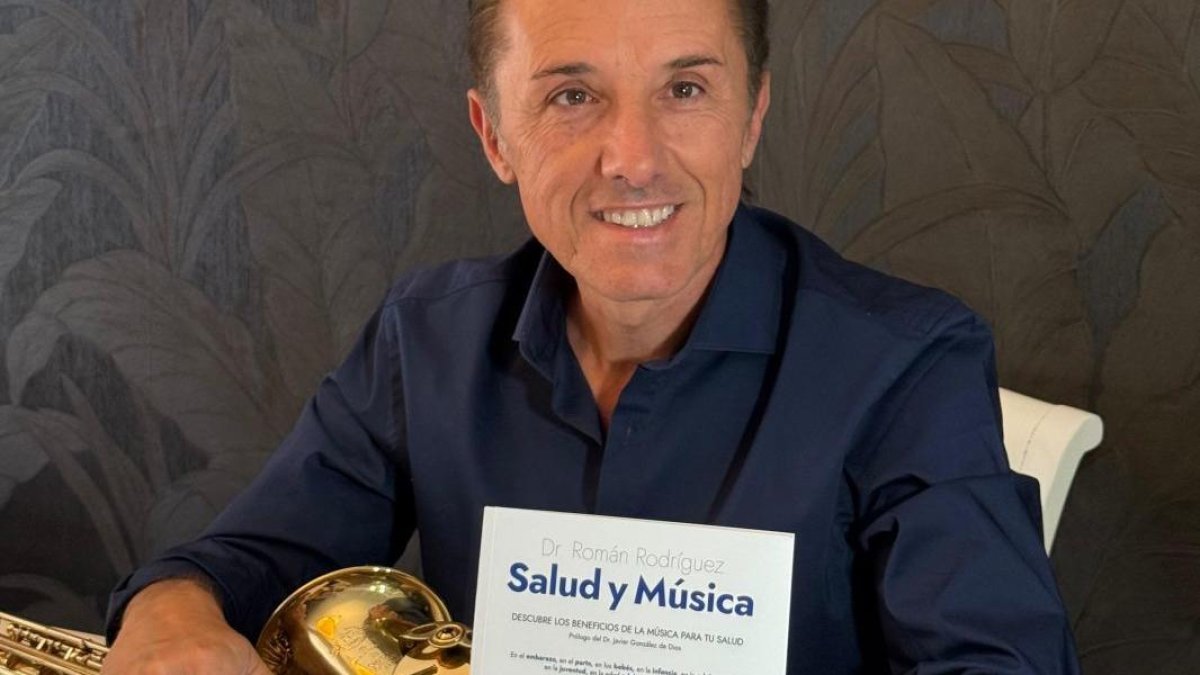 Román Rodríguez posa con su libro y el saxo, del que es músico especialista.