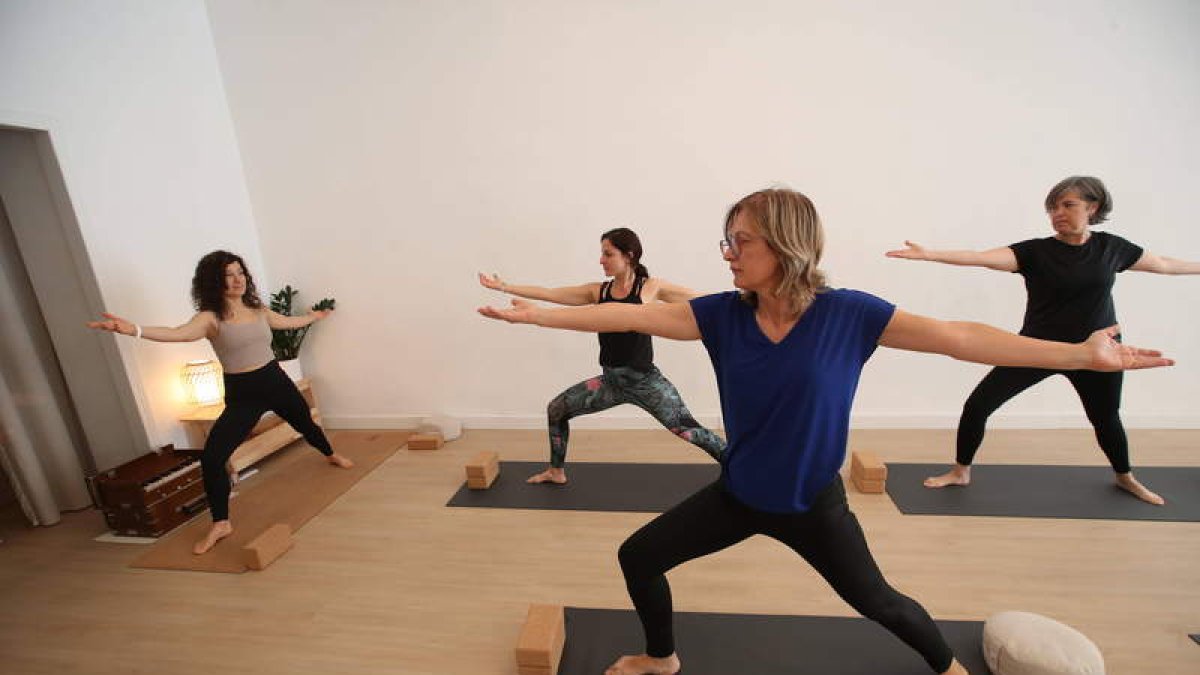 Arriba, Judith Martínez con alumnas en una clase de yoga. Junto a estas líneas, un par de rincones de Mueve tu alma. L. DE LA MATA / NOELIA