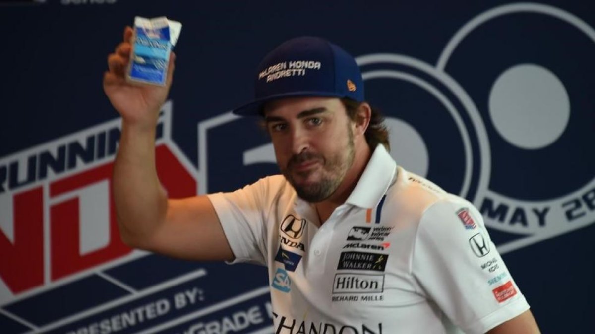 Fernando Alonso brinda con un brick de leche ante su eqUIPO.