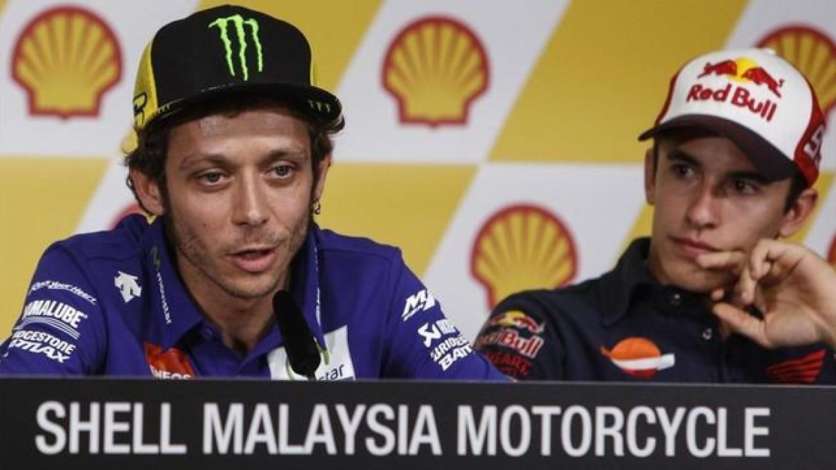 Valentino Rossi explica sus sensaciones antes del Gran Premio de Malasia, bajo la atenta mirada de Marc Márquez.