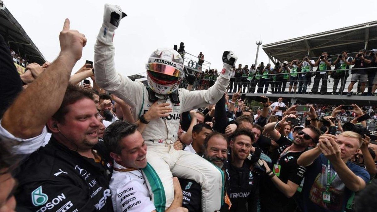 Hamilton es elevado por los mecánicos de Mercedes