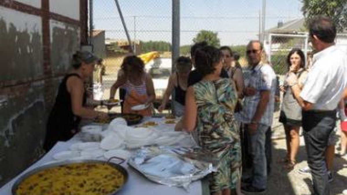 Momento en el que las mujeres se disponen a repartir las raciones de paella entre los vecinos.