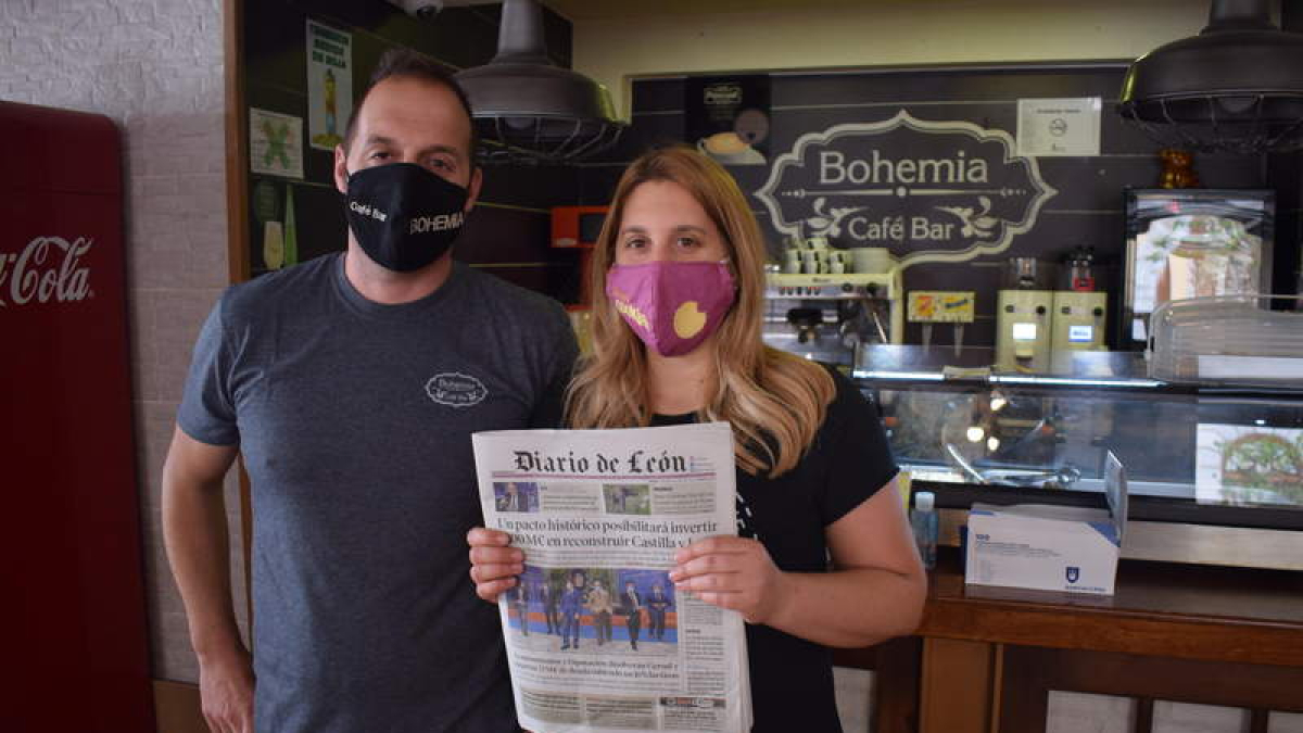 Toño y Miriam posan con el ejemplar del Diario de León de la cafetería Bohemia, del cual pueden disfrutar todas las personas que se acercan a este céntrico bar de La Bañeza. A. RODRÍGUEZ