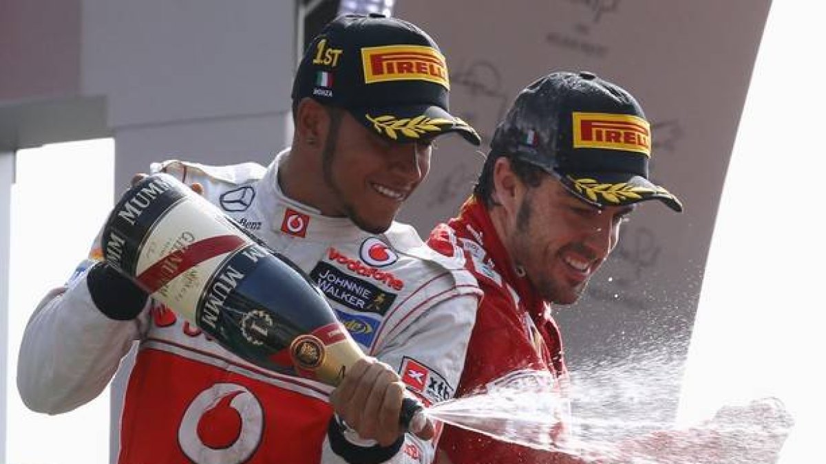 Lewis Hamilton y Fernando Alonso celebran su primer y tercer puesto, respectivamente, logrados en el circuito de Monza.