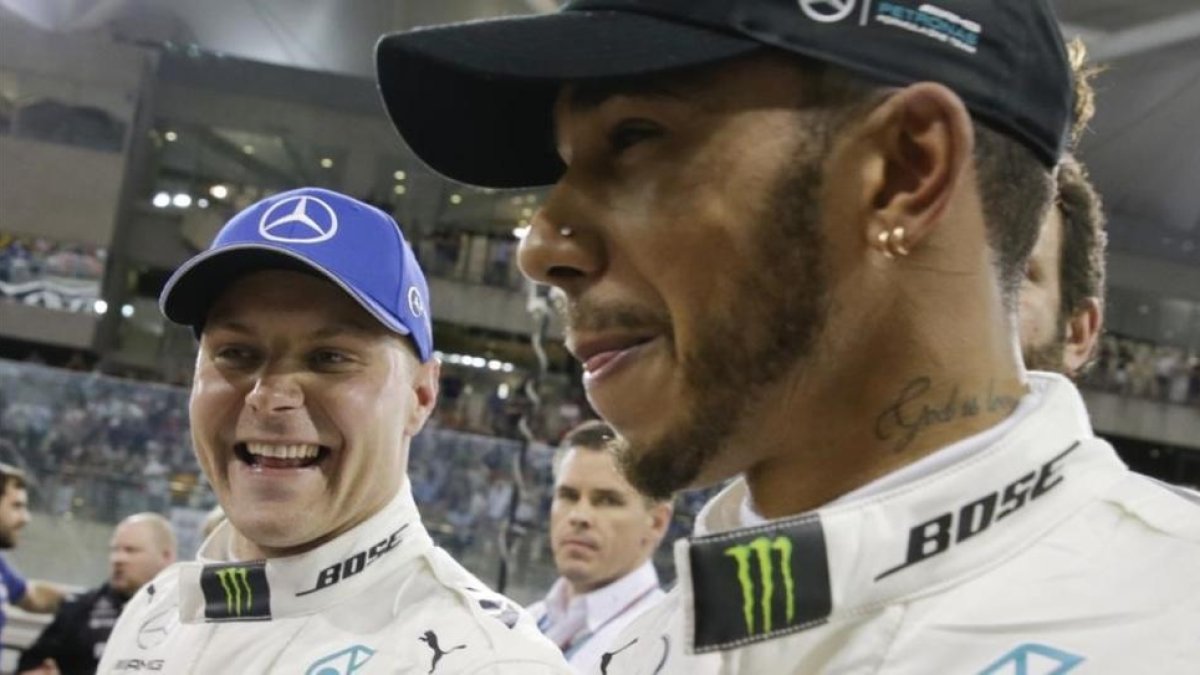 Valtteri Bottas y Lewis Hamilton sonrien tras lograr el finlandés la última pole de la temporada en Abu Dabi.