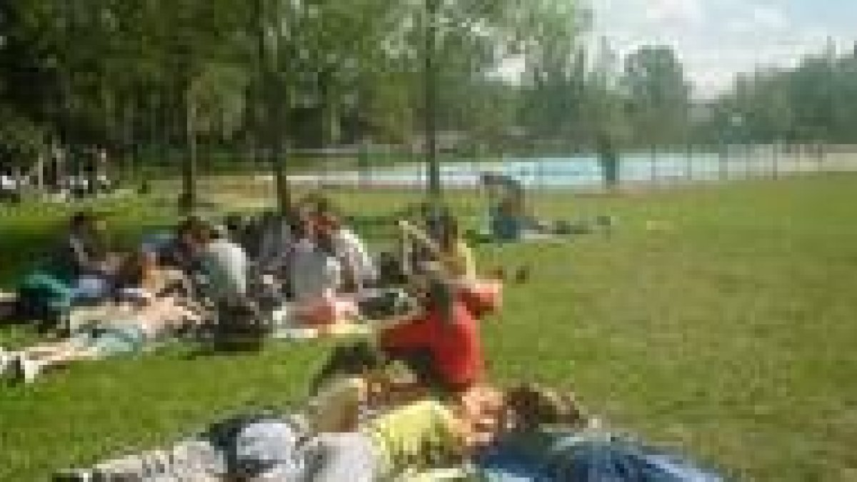 Varios jóvenes toman el sol en una piscina de la provincia durante las vacaciones estivales