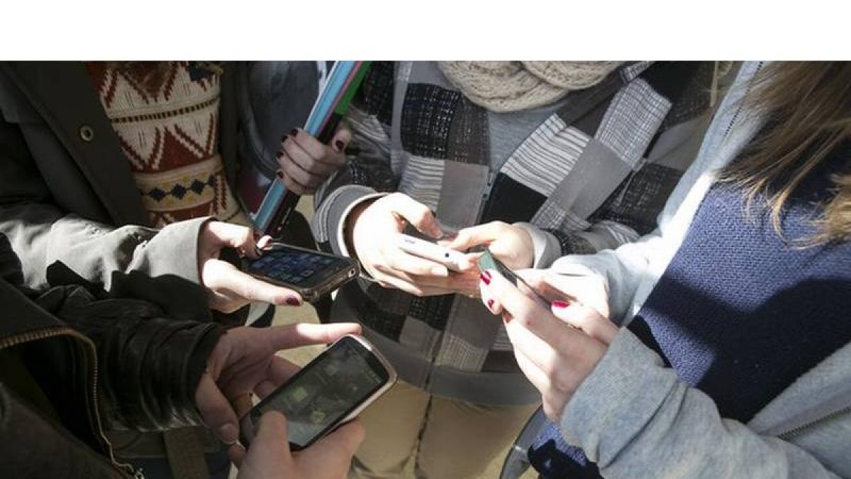 Un grupo de menores, con sus teléfonos móviles.