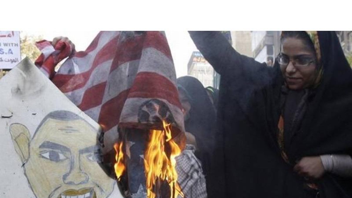 Una mujer quema una bandera estadounidense frente al edificio de la antigua embajada de EEUU, el 2 de noviembre del 2012.