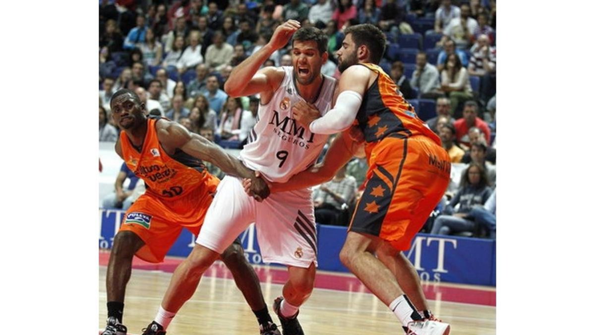 El madridista Reyes y los valencianistas Dubljevic y Sato, durante el partido disputado hoy en Madrid.