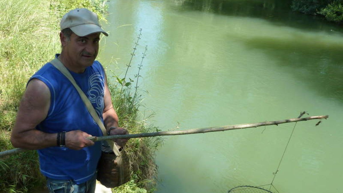 Un aficionado pesca cangrejos en las aguas del río Cea.