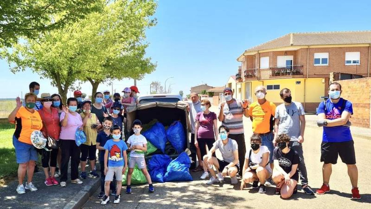 Imagen de los voluntarios con la basura recogida este sábado en Laguna de Negrillos. DL