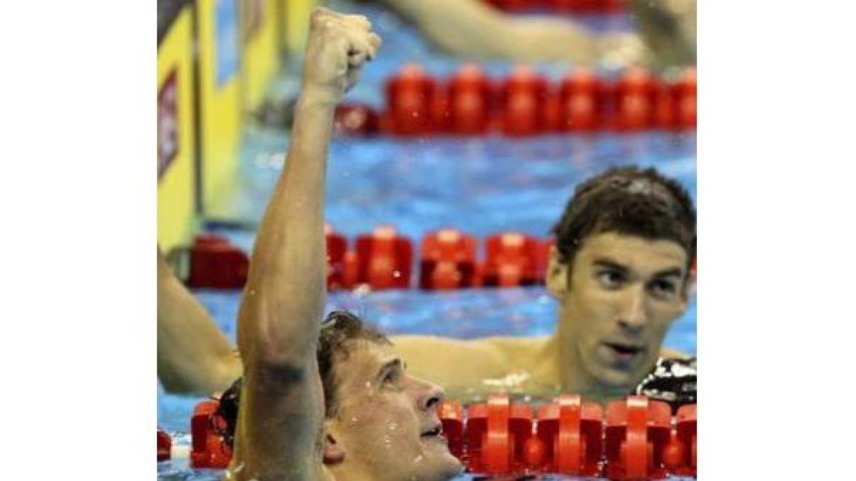 Ryan Lochte levanta el puño tras batir el récord mundial, con Phelps en la calle de al lado.