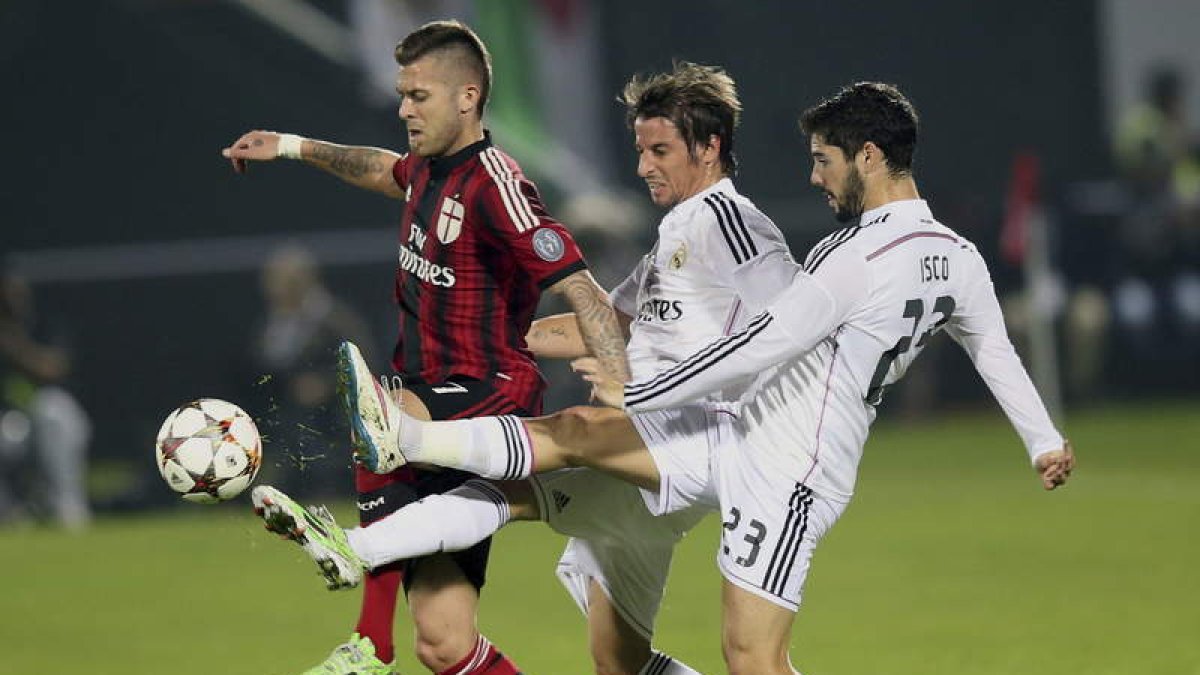 Menez, del Milan, pelea el balón con dos jugadores blancos: Fabio Coentrao e Isco.