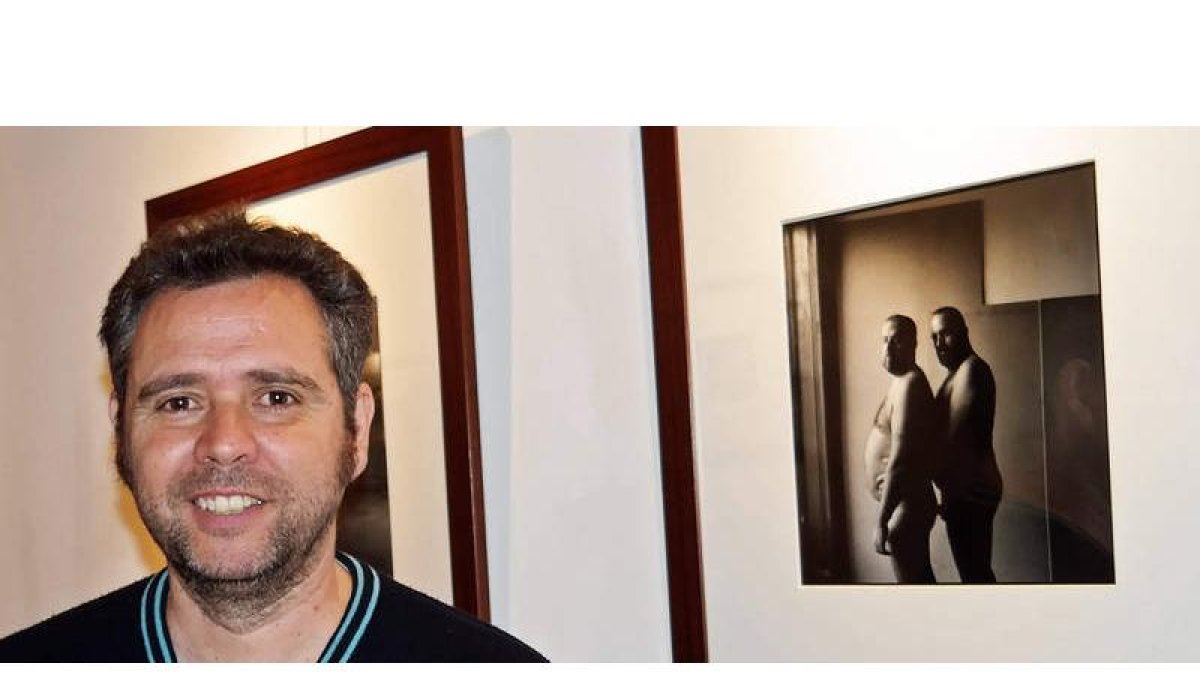 El fotógrafo asturiano Ricardo Moreno posa ante una de las obras que expone en la galería leonesa Cinabrio. CUEVAS