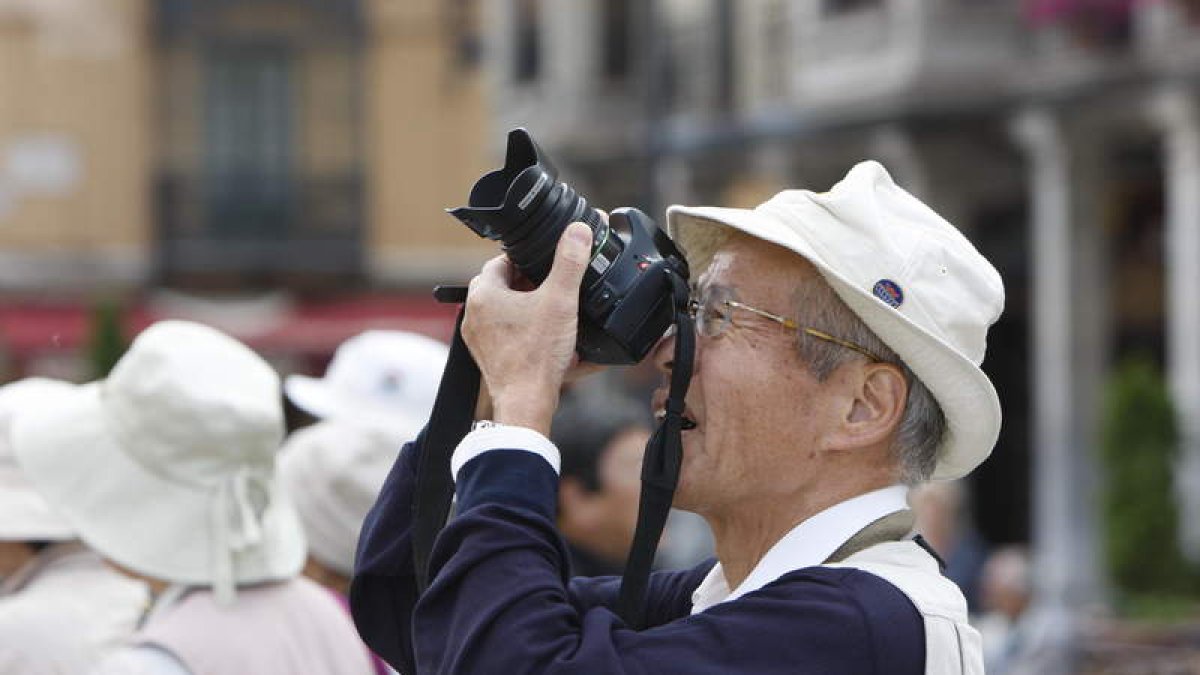 Un turista nipón toma imágenes de la fachada principal de la Catedral, acompañado de un grupo de compatriotas durante una visita a la capital leonesa en un tour por varias ciudades de España.
