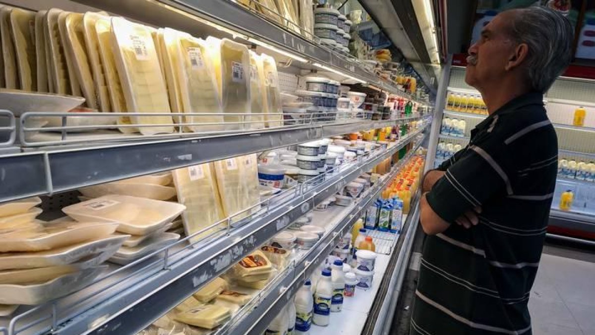Un hombre mira los precios en un supermercado.