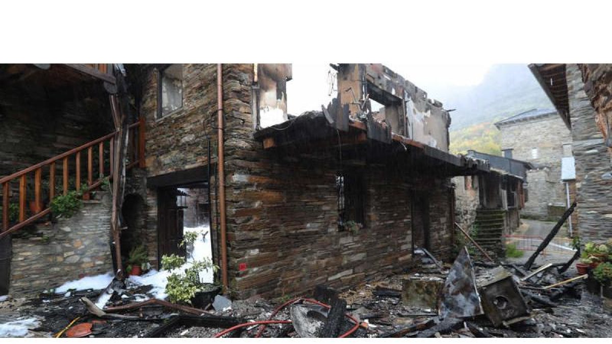 Con el amanecer la casa situada en el corazón de Peñalba donde se originó el incendio, a pocos metros de la iglesia mozárabe (al fondo), ofrecía un aspecto de ruina total. ANA F. BARREDO