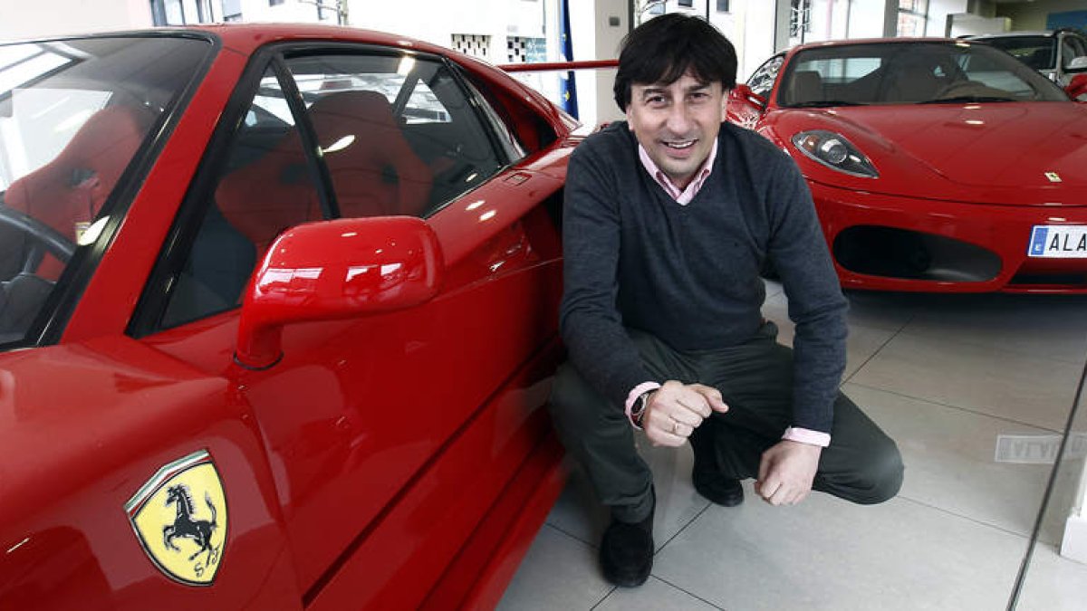 Alonso García, propietario de Alauto, posa con los dos modelos de Ferrari que luce su concesionario.