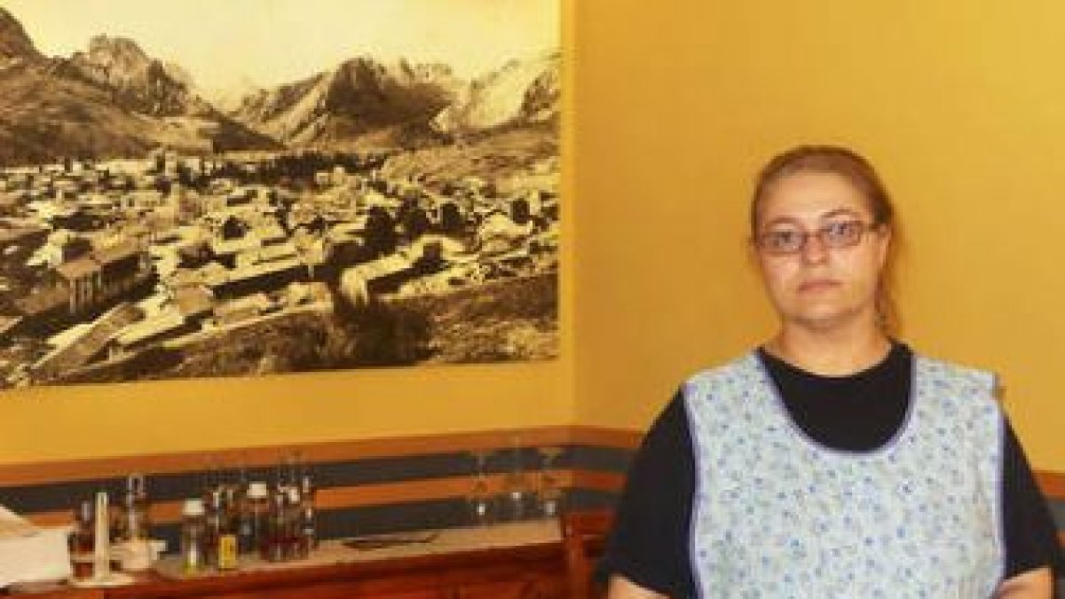 Gloria posa ante una foto del viejo Riaño que preside el comedor de su restaurante.