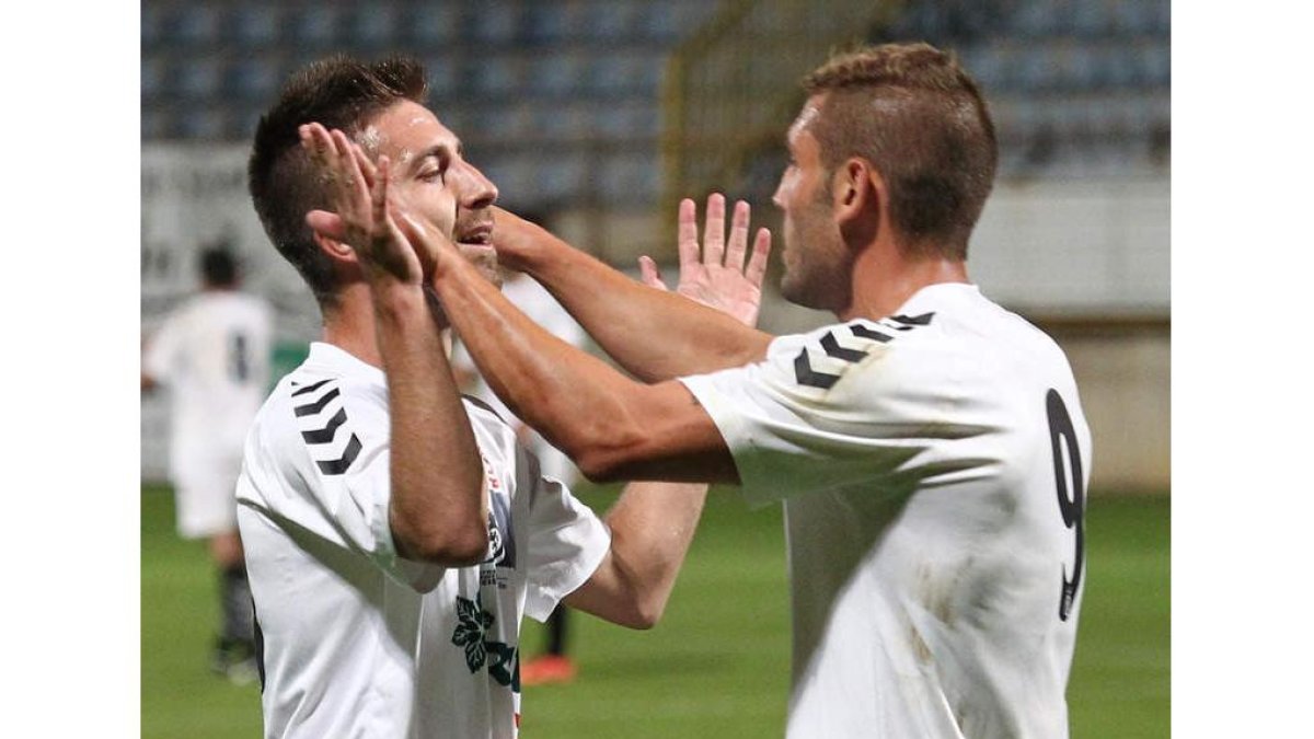 Jony Lomas, a la izquierda, celebra un gol con Diego Torres.