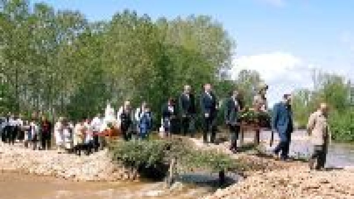 Los vecinos cruzaron el puente llevando las imágenes de san Jorge y la Virgen del Rosario