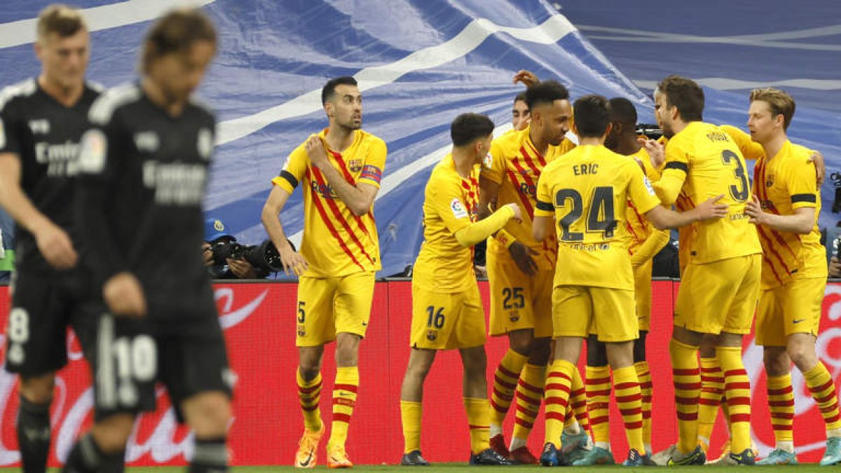Los jugadores del FC Barcelona celebran la victoria del equipo blaugrana ante Kroos y Modric, cabizbajos después de la exhibición culé en el Bernabéu. BALLESTERO
