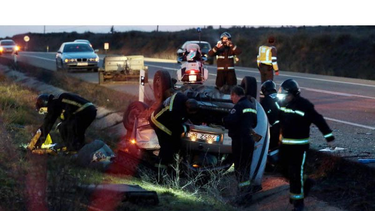 Efectivos del Cuerpo de Bomberos, durante las labores de rescate del cadáver en la cuneta de la carretera .