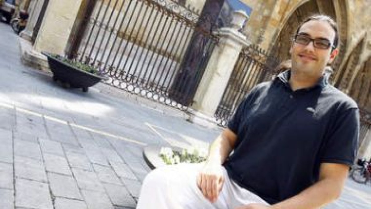 Aitor Olivares, director del Coro Ángel Barja, sentado delante de la Catedral de León